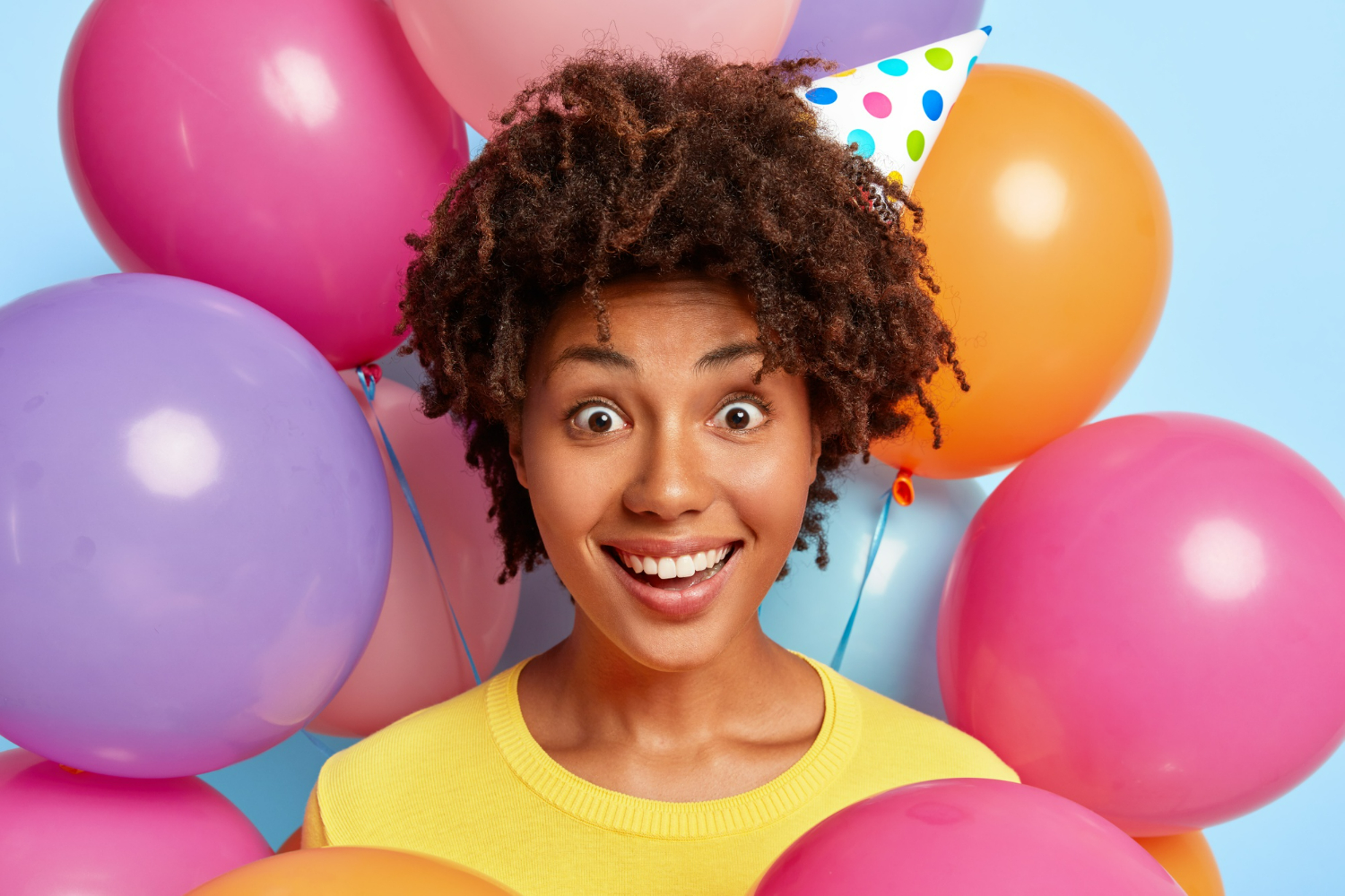 winsome young woman posing surrounded by birthday colorful balloons 1
